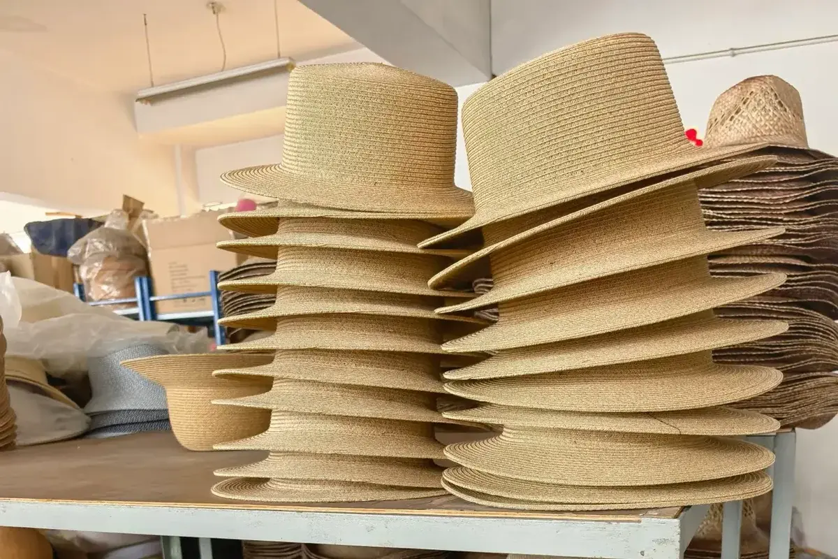 Stacks of flat-crown boater hat bodies arranged in the sample room