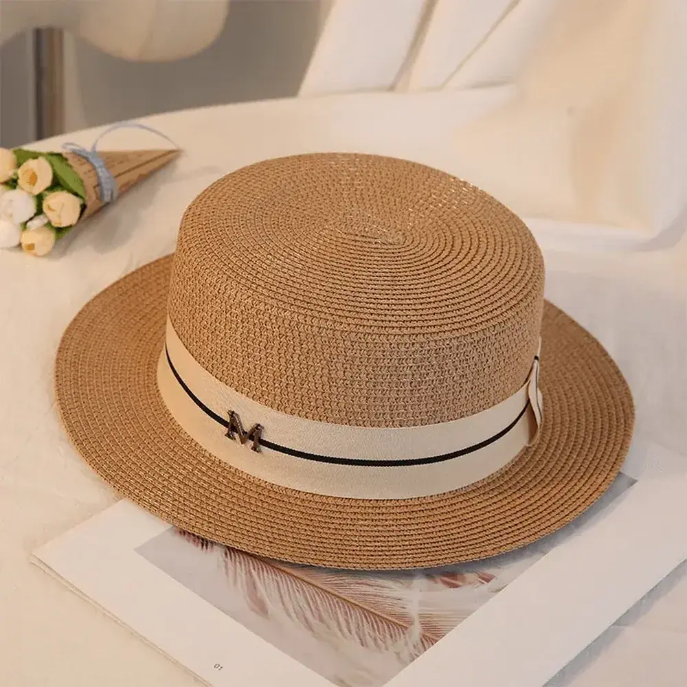 Brown flat-top boater hat with a light ribbon and metal accent