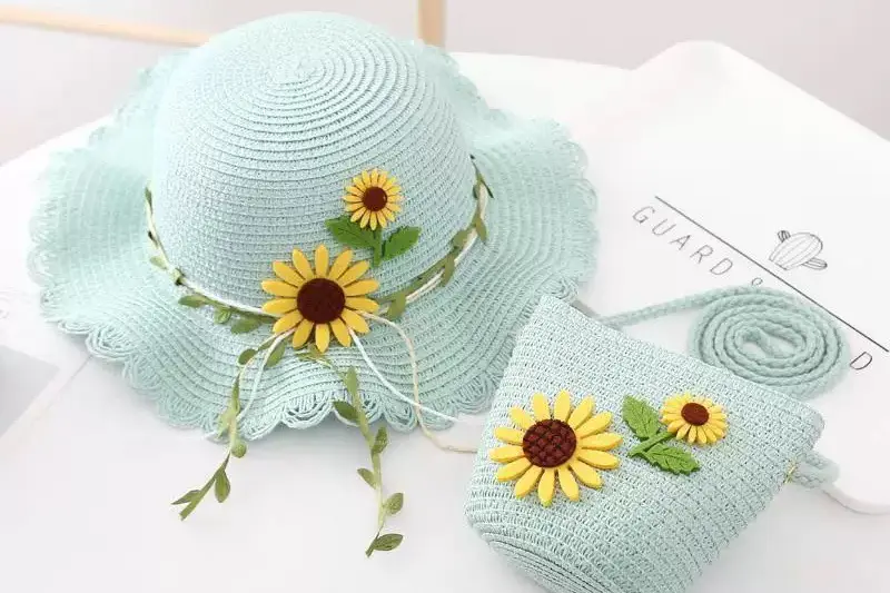 Blue kids straw hat with a small daisy detail and proportioned ribbon band