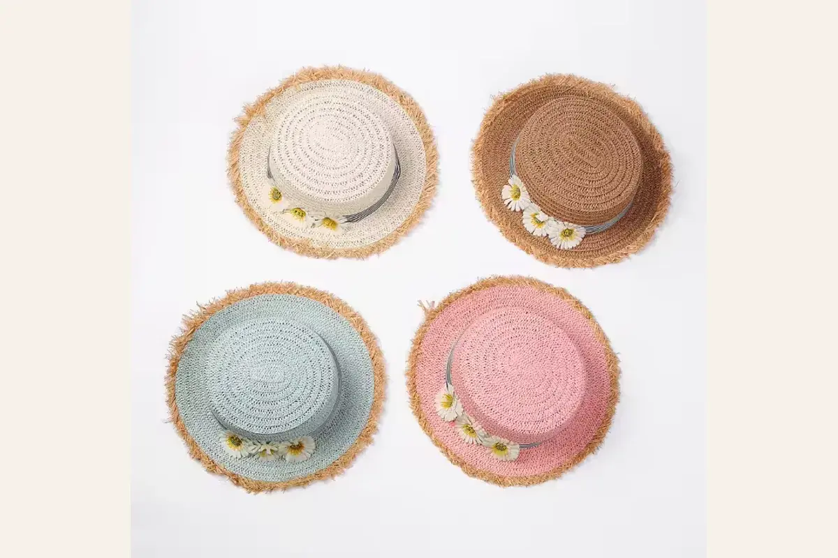 Four child-size straw hats in coordinated white, brown, blue, and pink colors