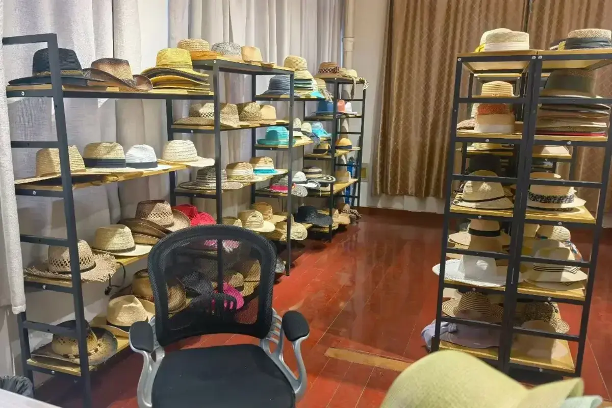 Straw hat samples arranged on display racks in the LuxoHat sample room