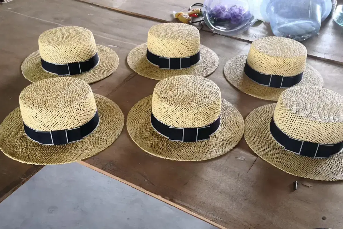 Six Panama-style straw hats with coordinated black hat bands