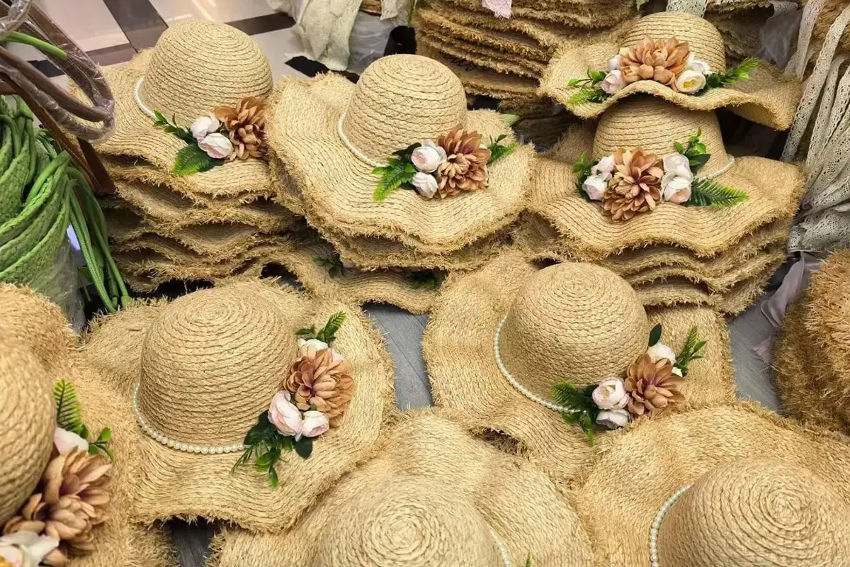 Raffia hats decorated with floral trims for gift and event projects