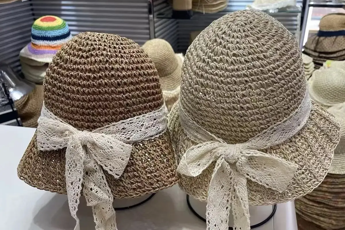 Pair of raffia hats finished with decorative lace bows