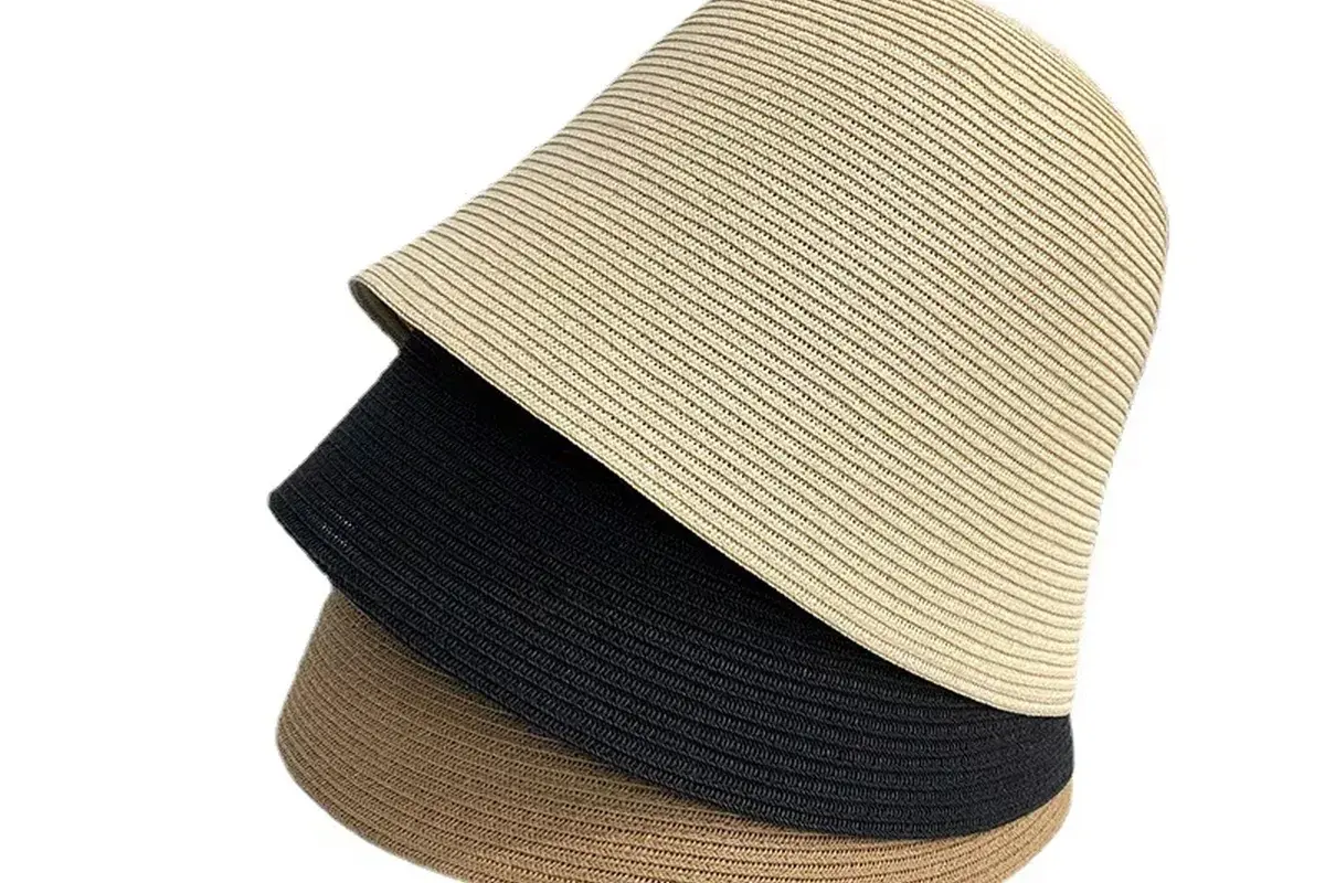 Three nested straw bucket hats showing a compact packing direction