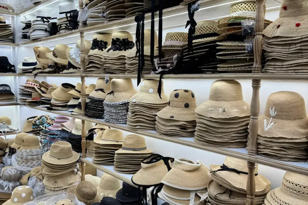 Fedora and straw hat samples arranged on factory development shelves