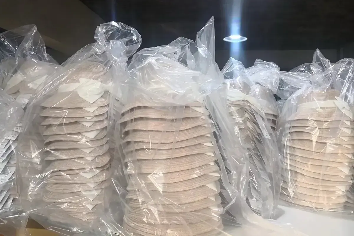 Finished straw hat bodies protected in clear bags for bulk packing