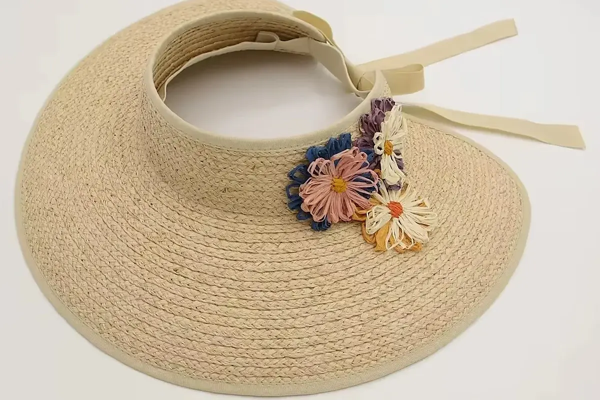 Natural straw visor with a floral badge detail beside the headband