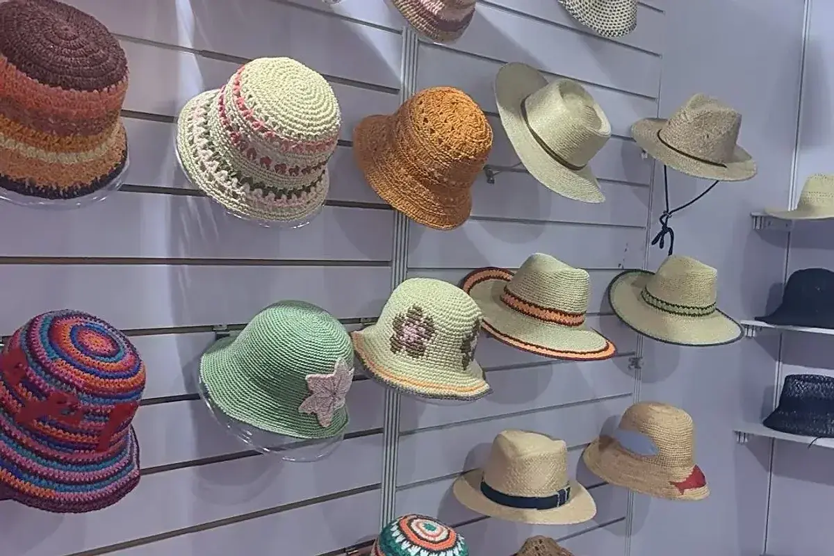 Colorful crocheted and straw hat samples displayed in the factory showroom