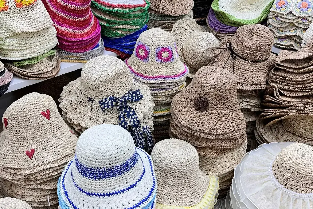 Crocheted straw hats with coordinated colored bands, embroidery, bows, and trims
