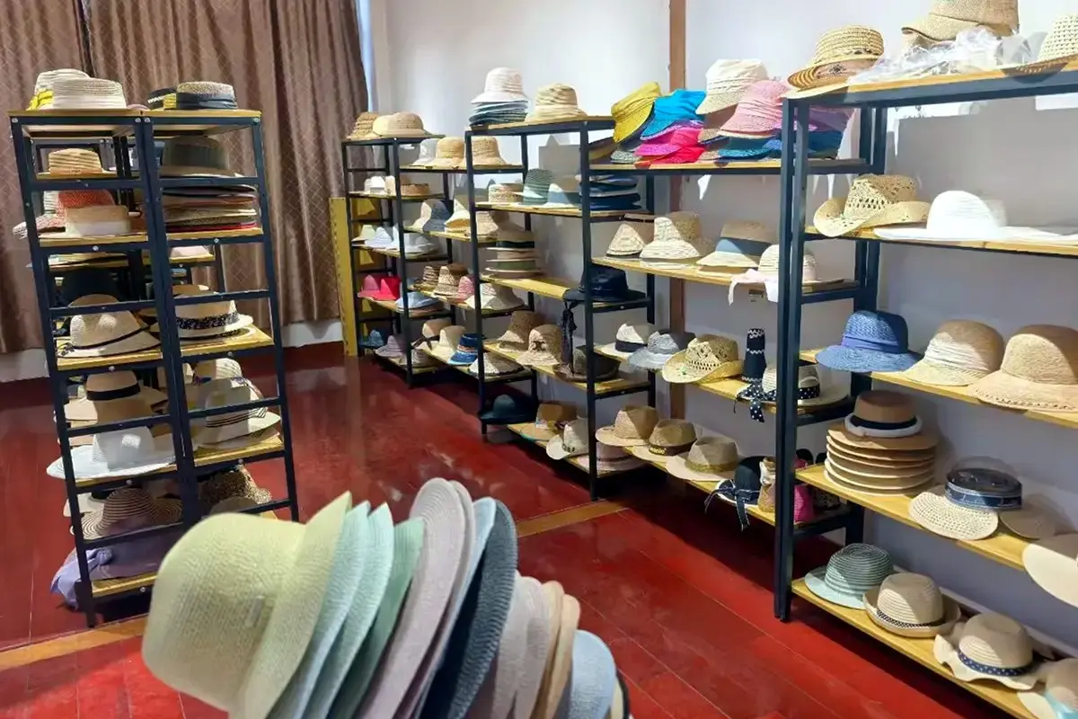 Straw hat samples arranged across the LuxoHat factory sample room