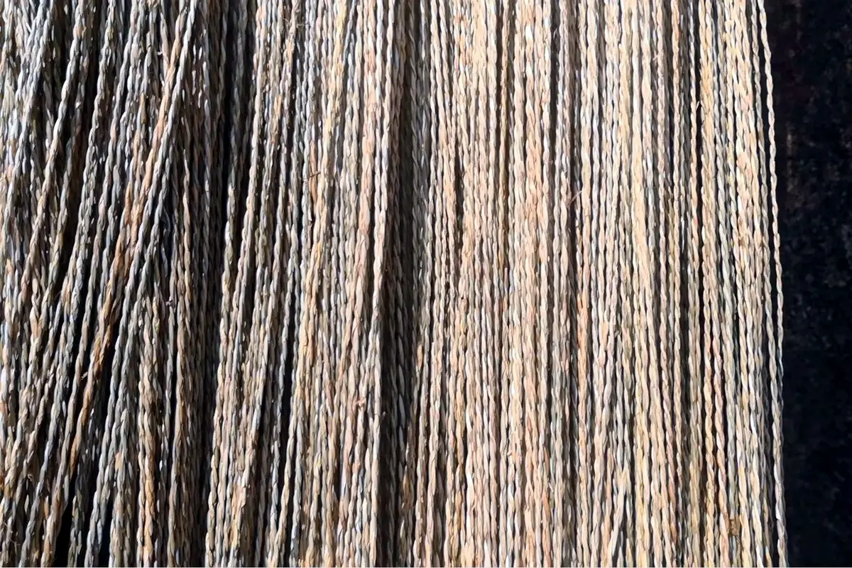 Natural straw and paper material strands arranged for custom hat production