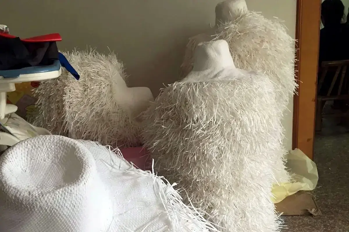 Unfinished raffia hat bodies showing natural fiber texture and fringed edges