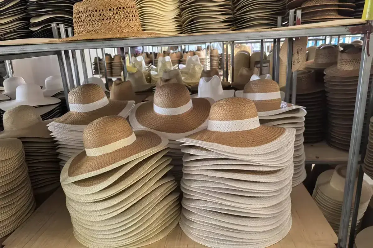 Factory stacks of finished straw hats prepared to one consistent size specification