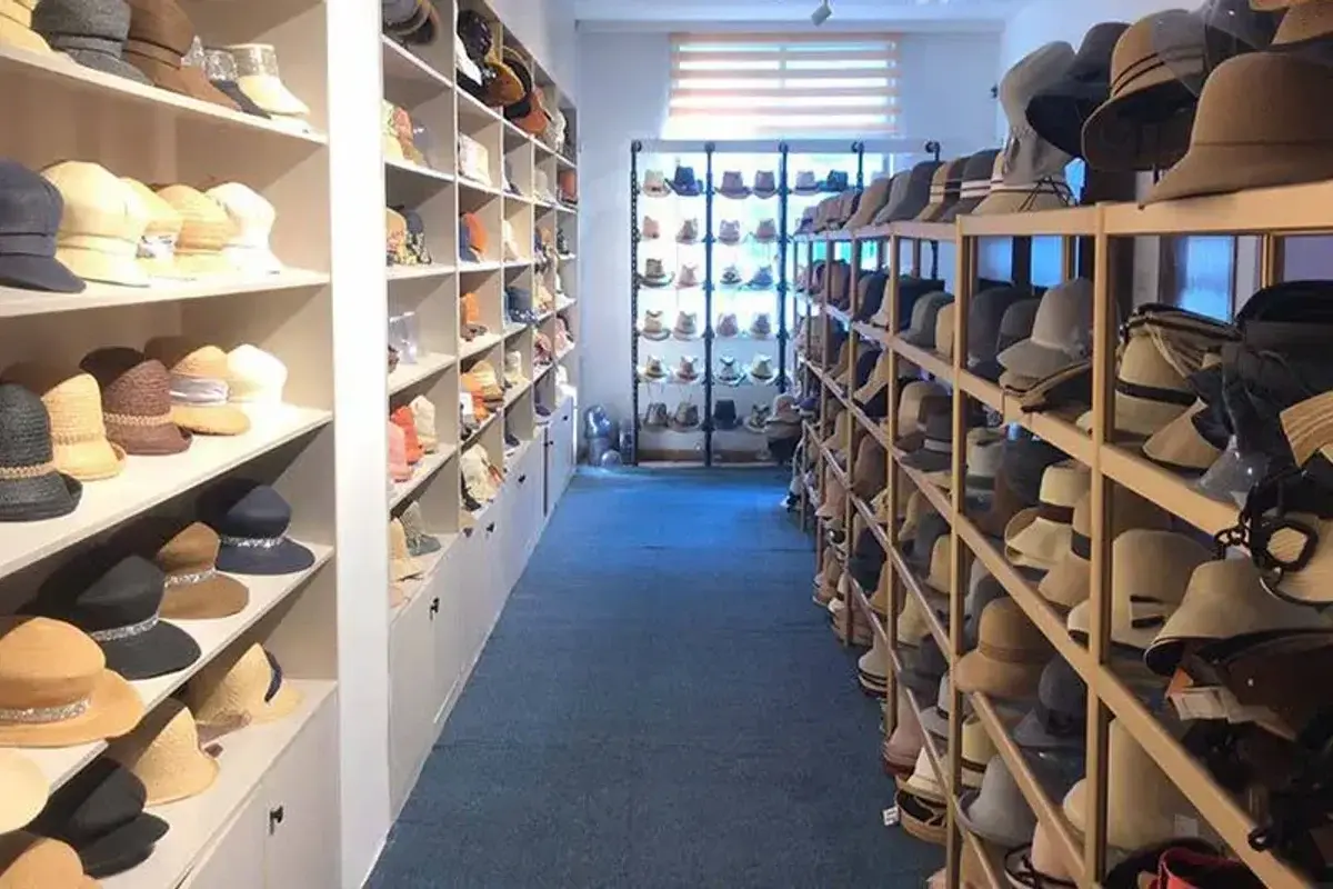 Factory straw hat sample room with multiple crown, brim, and size profiles