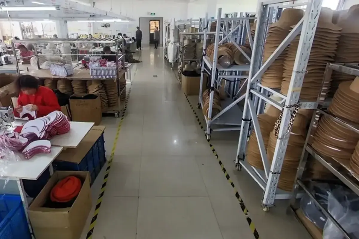 Factory production aisle with workers and straw hat bodies ready for assembly