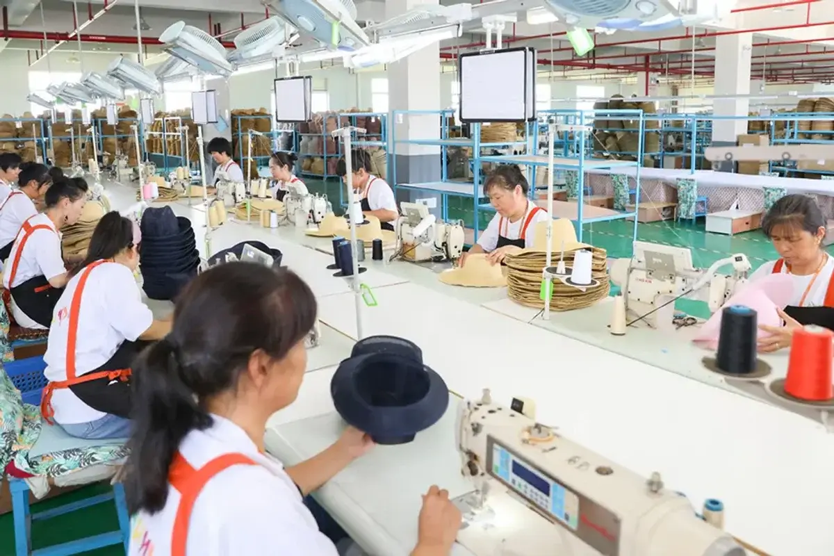 Straw hat factory team sewing and assembling hats on the production line