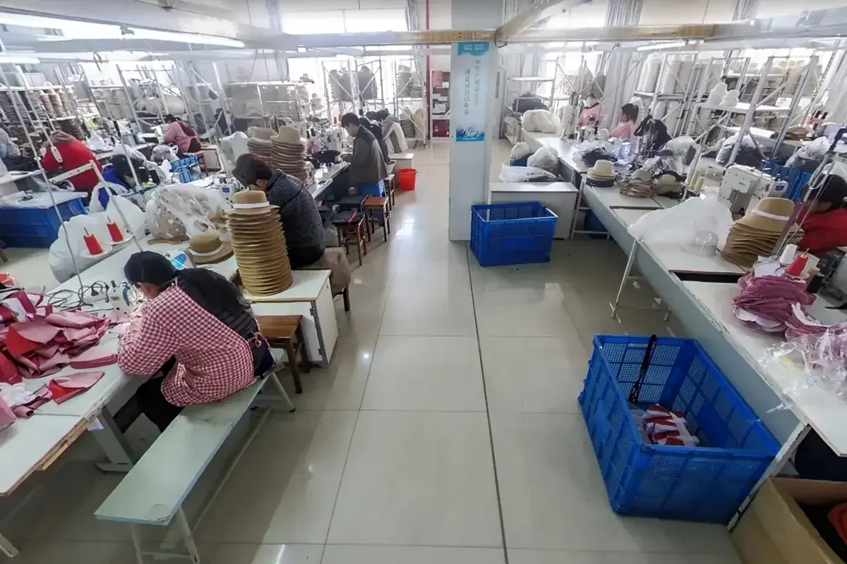 Factory team working across two straw hat sewing and assembly lines