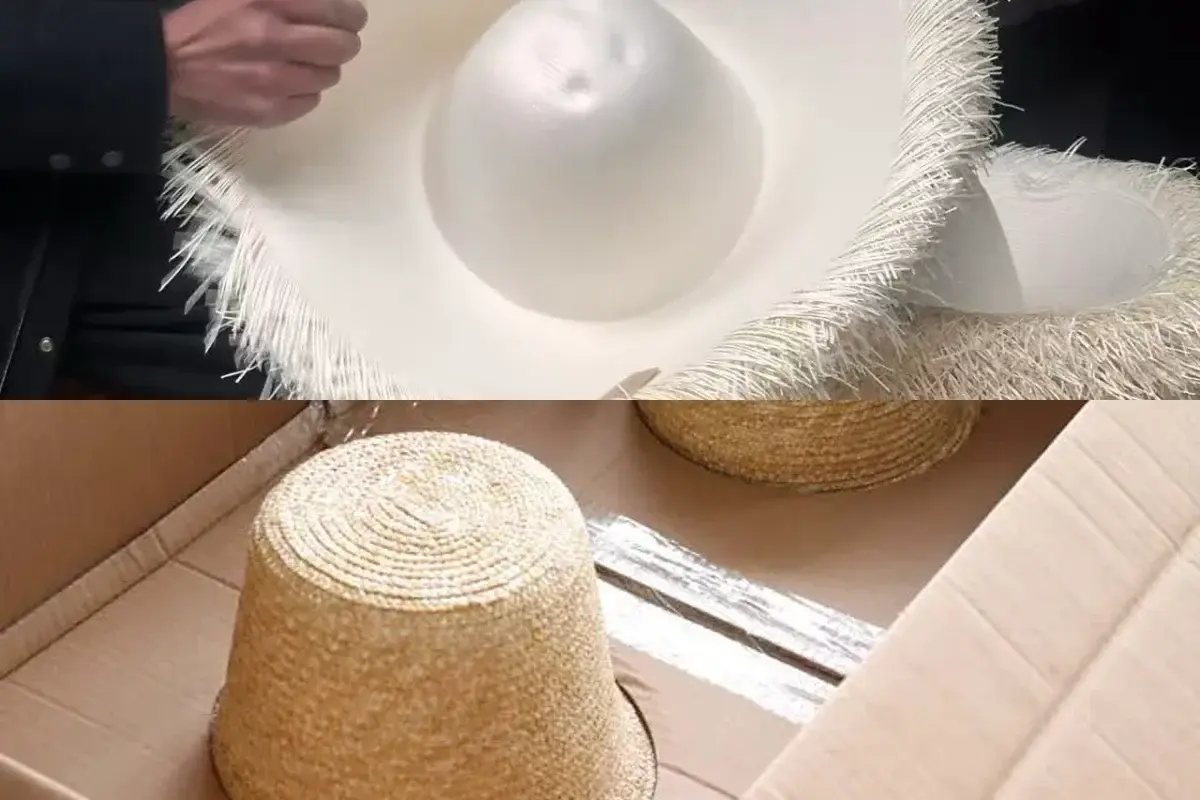 Hand inspection of a straw hat above hat bodies arranged in a shipping carton