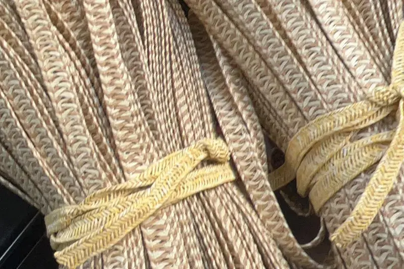 Bundles of woven straw hat braids showing different textures