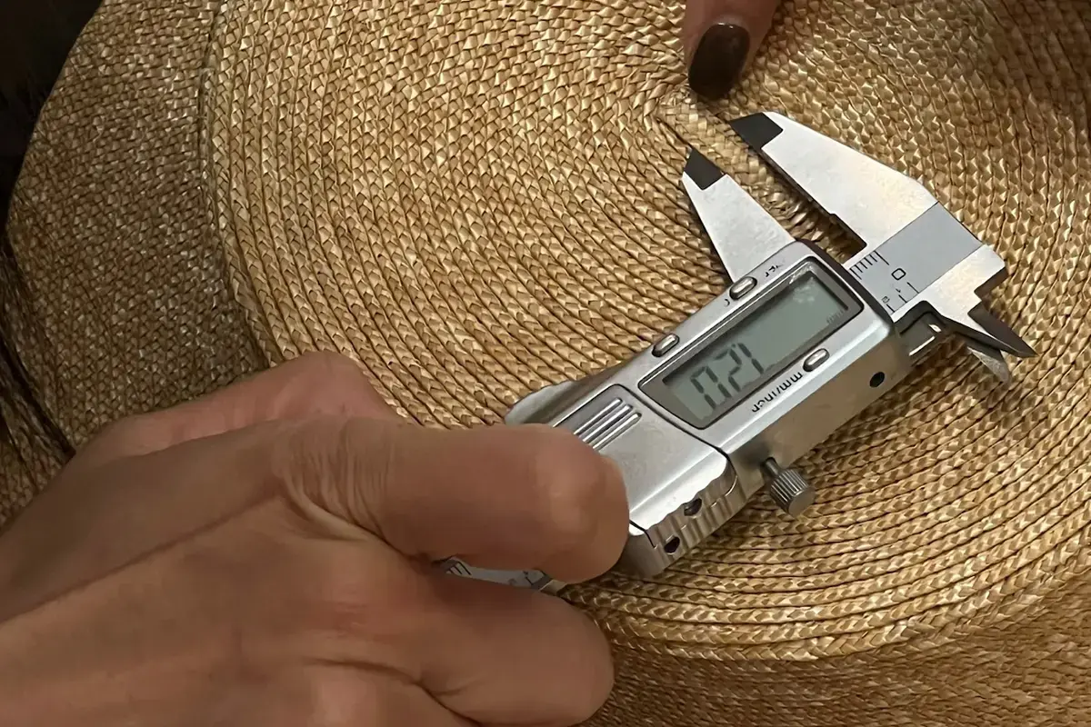Caliper measuring a straw hat brim during production inspection
